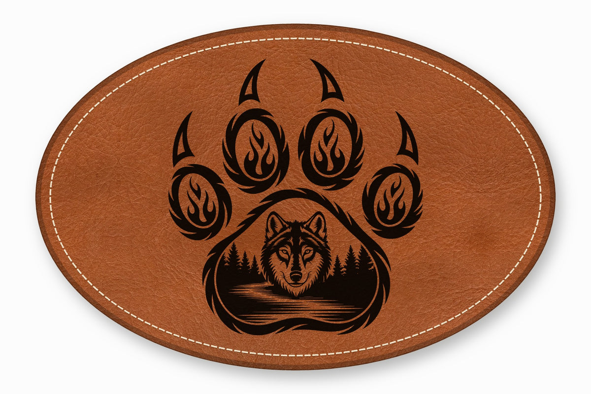 An oval brown leather patch featuring a black engraved bear paw and a wolf head forest scene.
