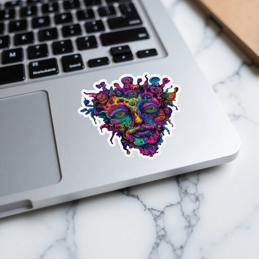 Colorful abstract face sticker with many eyes on a laptop keyboard