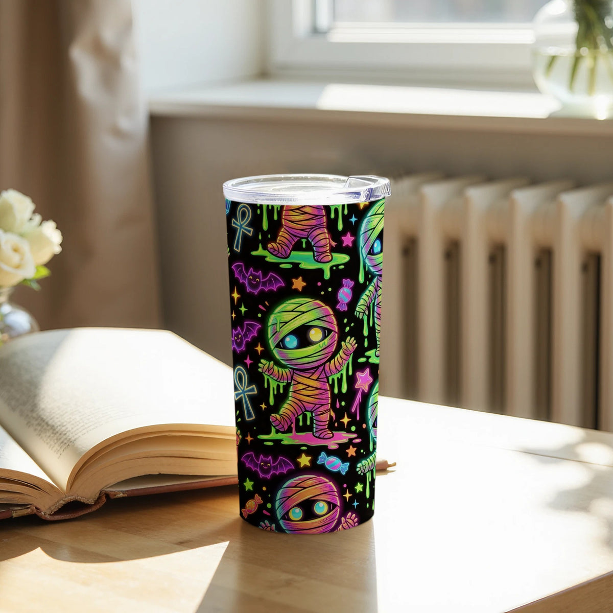 Tumbler with a repeating pattern of cartoon mummies, bats, and candy.