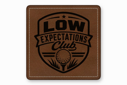 Brown leather patch with white stitched border and a black golf-themed Low Expectations Club logo.