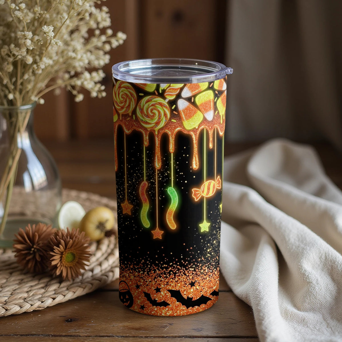Black tumbler with dripping candy, Halloween bats, and glitter accents.