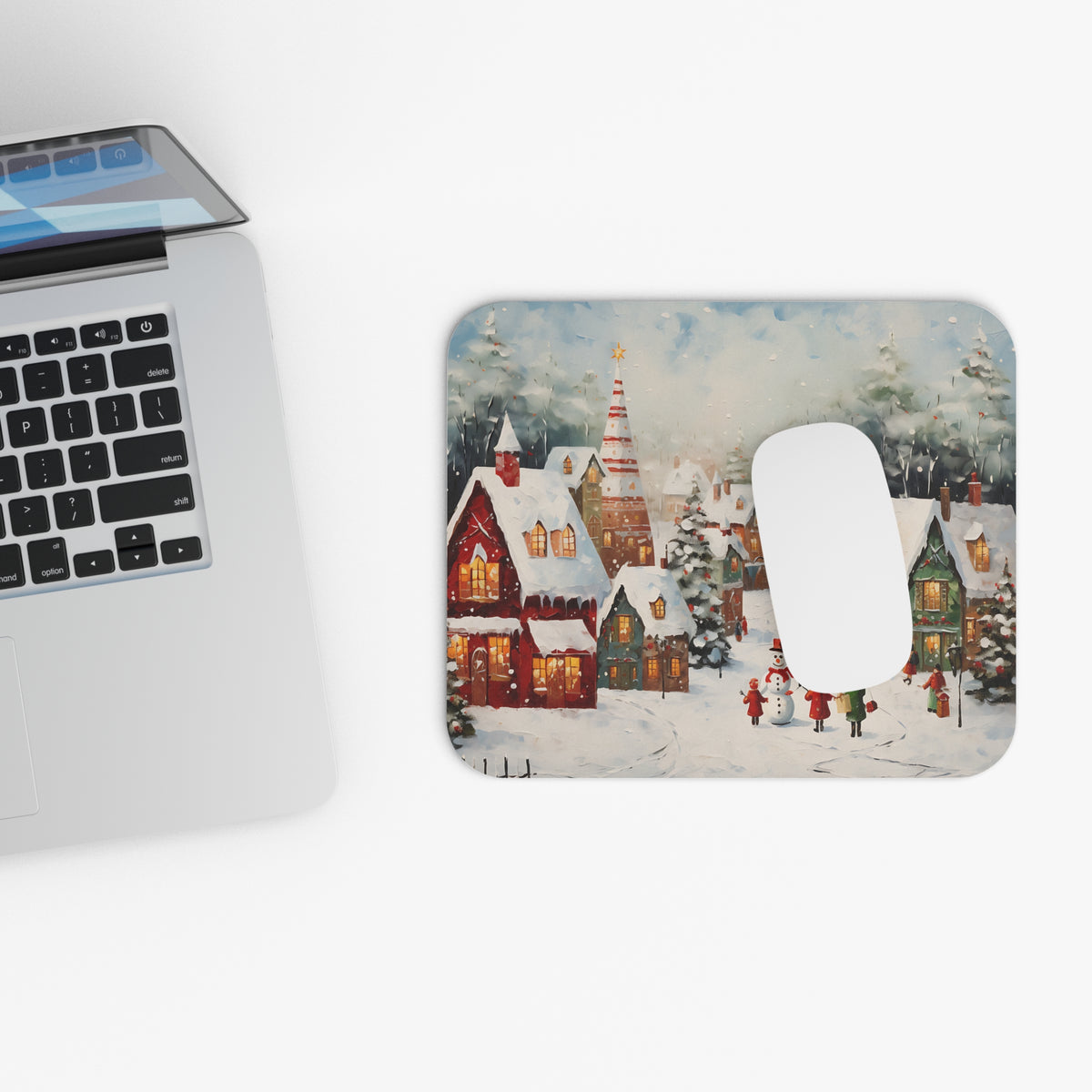 Mousepad with a festive winter village painting and a white mouse.