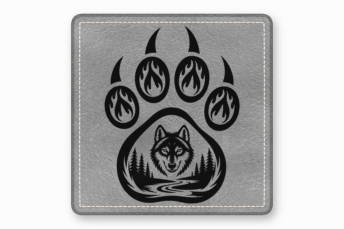 Grey square leather patch featuring a black bear paw with flame and forest designs.