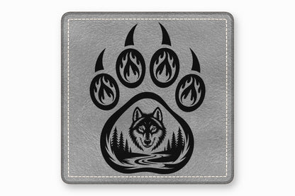Grey square leather patch featuring a black bear paw with flame and forest designs.