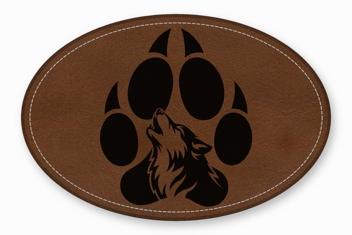 Oval brown leather patch with white stitching and a black paw print containing a howling wolf.