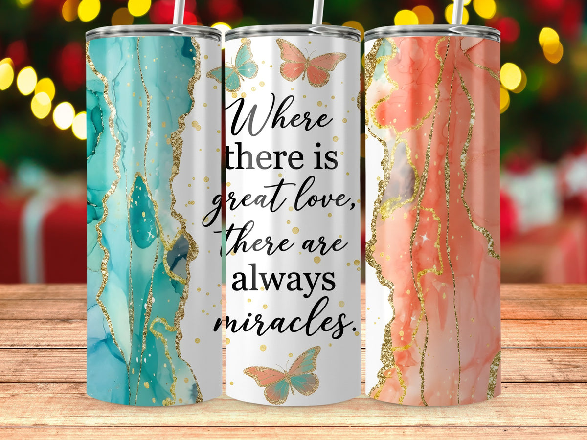 Three tumblers with marble and glitter designs, one with text.