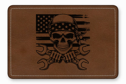 Brown leather patch laser-engraved with a skull wearing a bandana over a distressed American flag and crossed wrenches.