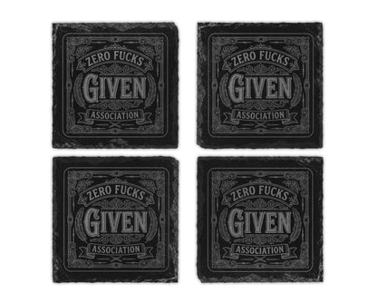 Set of four slate coasters with "Zero Fucks Given Association" text and decorative elements.