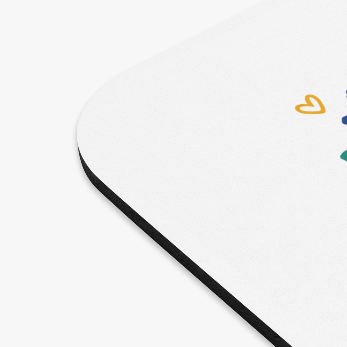 White mousepad with black edge and scattered colorful heart shapes.