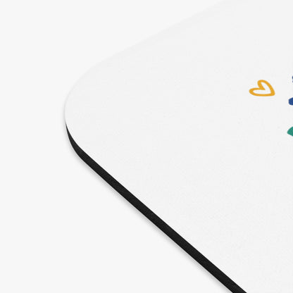 White mousepad with black edge and scattered colorful heart shapes.