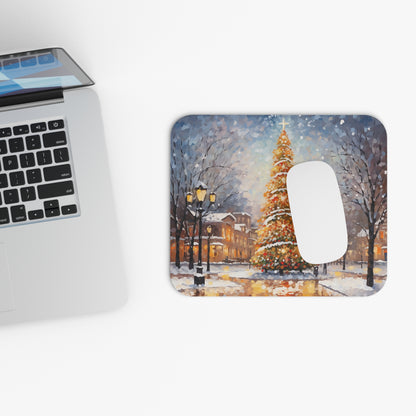 Mousepad with a watercolor painting of a snowy town square with a decorated Christmas tree.