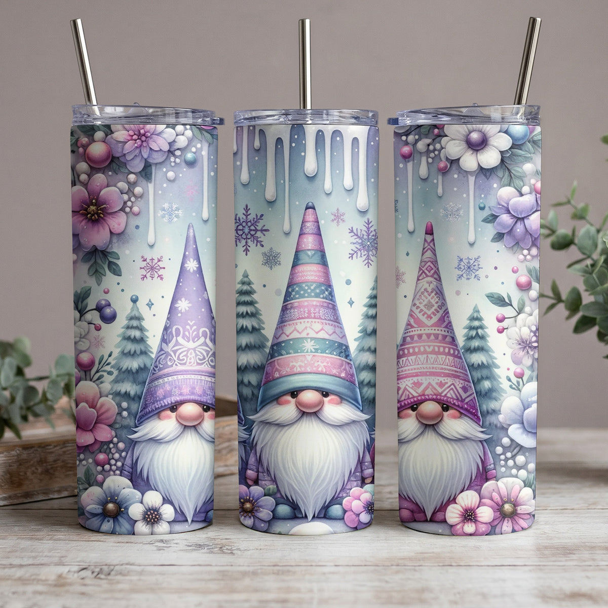 Three tumblers with watercolor gnomes, winter trees, and flowers designs.