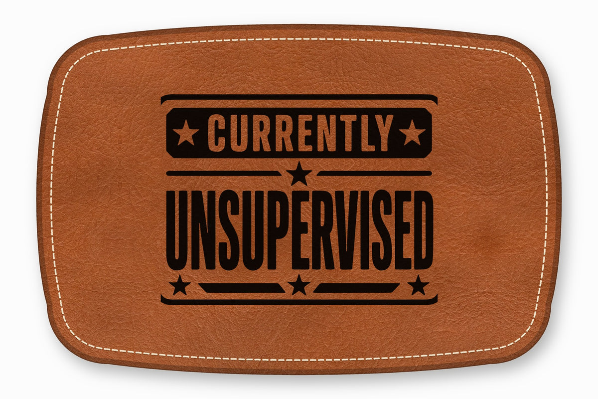 Brown leather patch featuring white stitching along the edge and black text reading Currently Unsupervised.