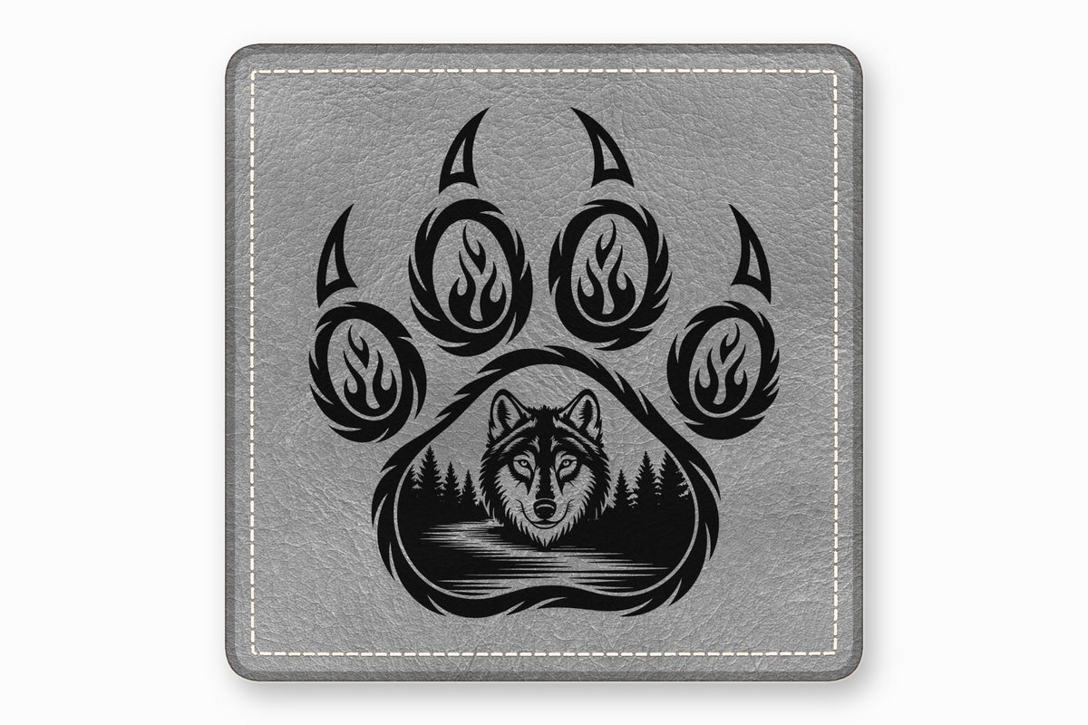 Square grey faux-leather coaster featuring a black wolf and forest graphic inside a bear paw print.