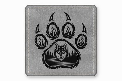 Square grey faux-leather coaster featuring a black wolf and forest graphic inside a bear paw print.