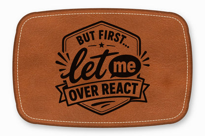 Brown leather patch with white stitched edges and black text that reads "But first... let me over react".