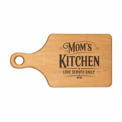 Wooden cutting board with text "Mom's Kitchen, Love Served Daily".