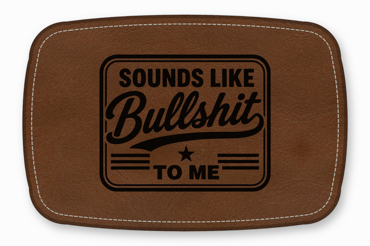 Brown leather patch with white stitching and the engraved text Sounds Like Bullshit To Me.