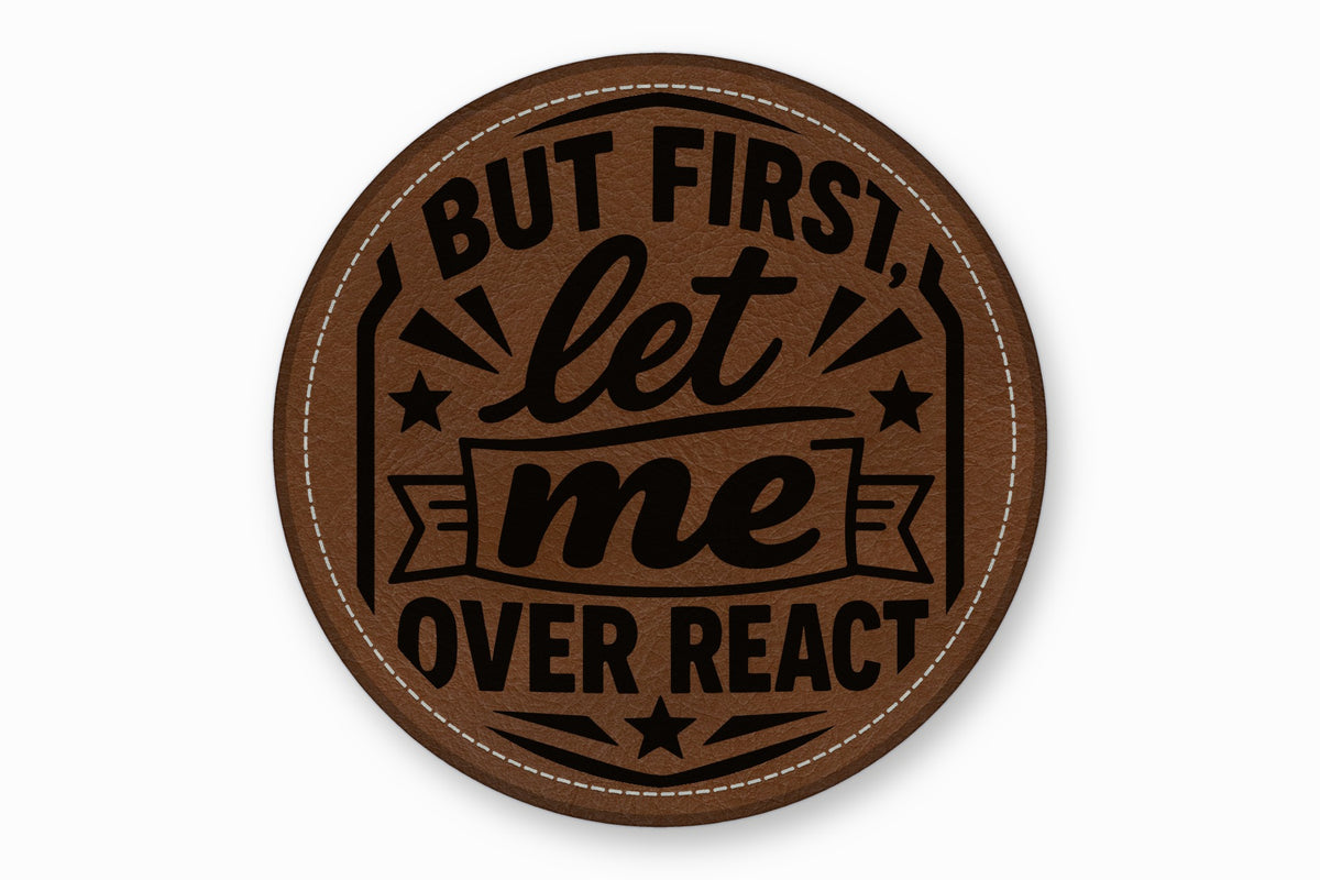 Round brown leather patch with white stitched border and black text reading But first, let me overreact.