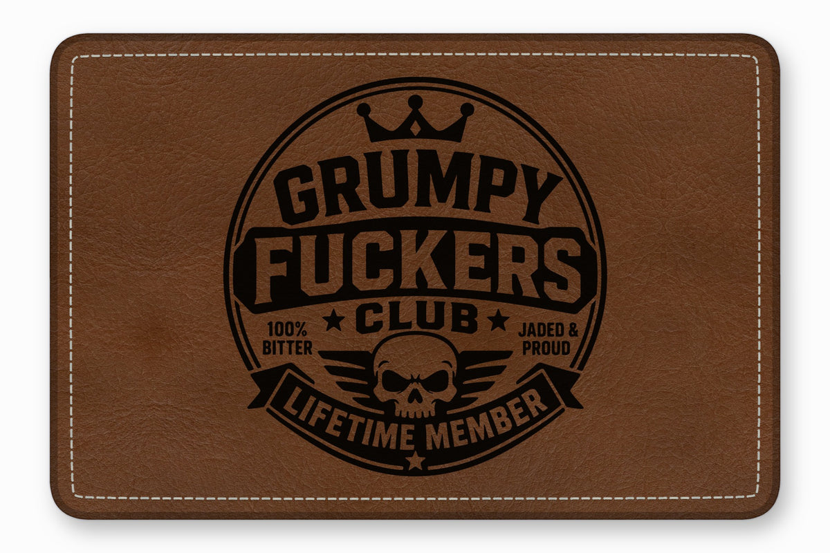 Brown leather patch with rounded corners, white stitching, and a black skull emblem and text.