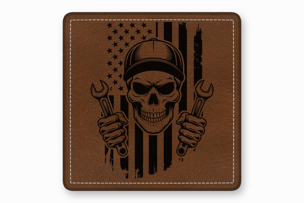 Brown leather patch featuring a black engraved mechanic skull wearing a cap and holding wrenches against an American flag.