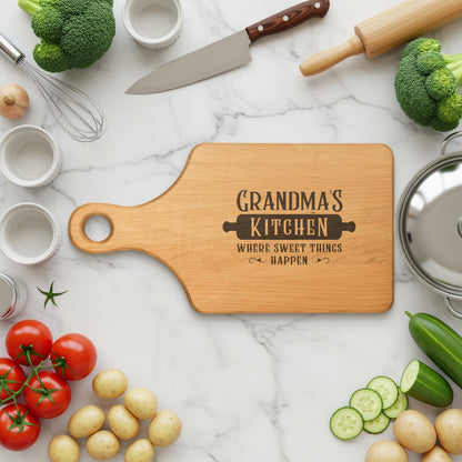 Wooden cutting board with "Grandma's Kitchen Where Sweet Things Happen" engraved text.