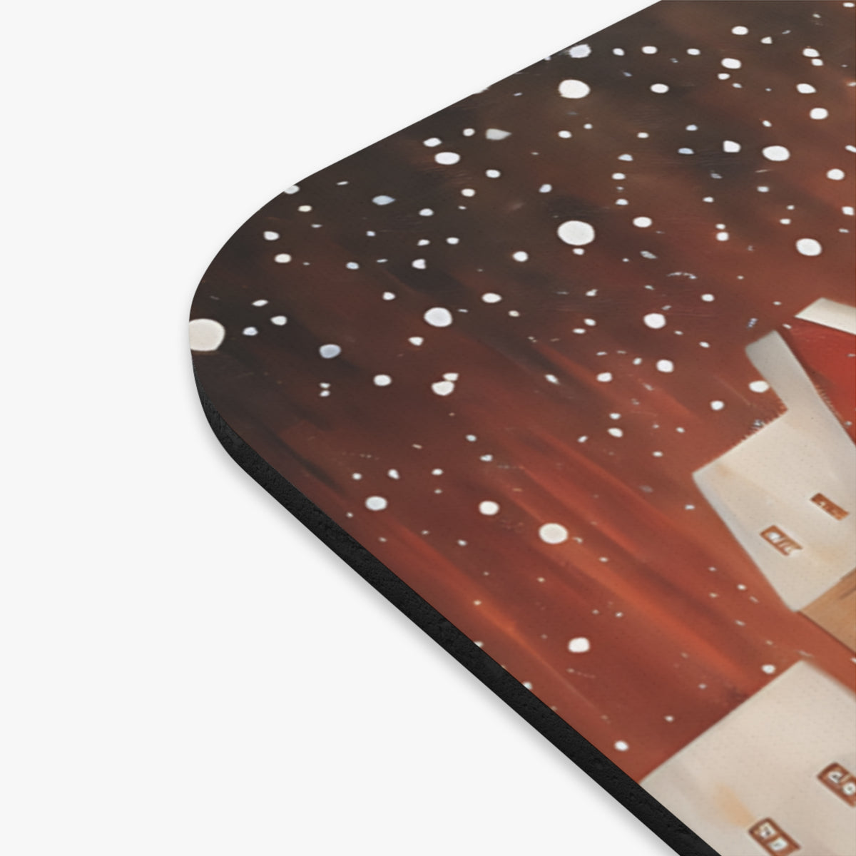 Mousepad with painted houses and falling snow in a winter scene.