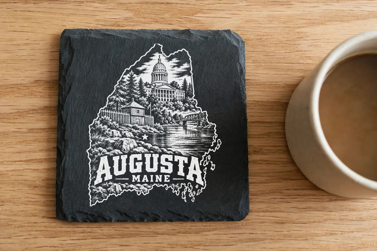 Square black slate coaster engraved with an outline of Maine, Augusta landmarks, and the text Augusta Maine.