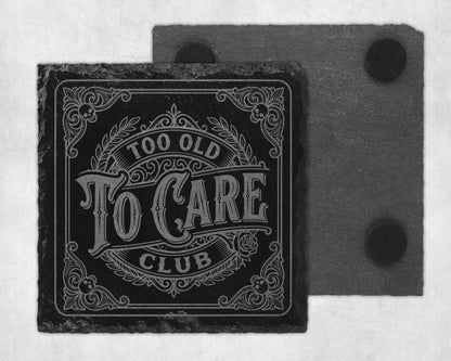 Square slate coaster with etched text "Too Old To Care Club" and decorative border.