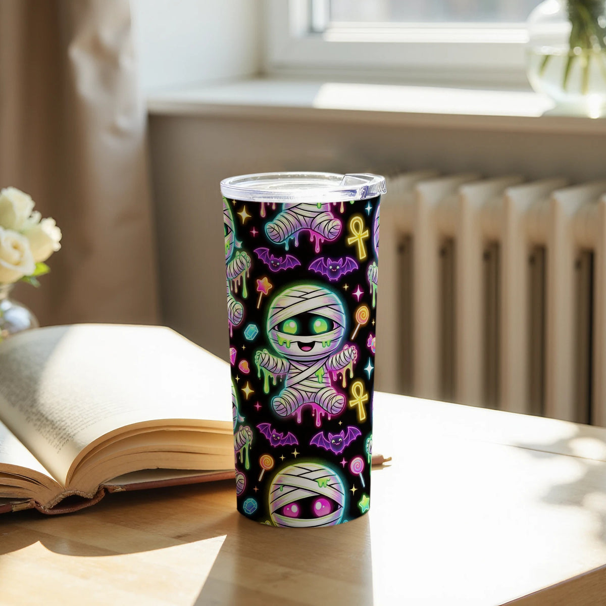 Tumbler with a pattern of cute, glowing mummies, bats, and lollipops on black.