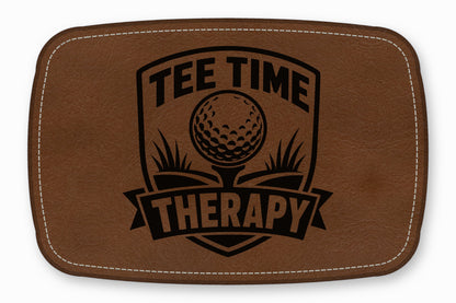 Brown leather patch with rounded corners, white stitching, and a black golf-themed design reading Tee Time Therapy.