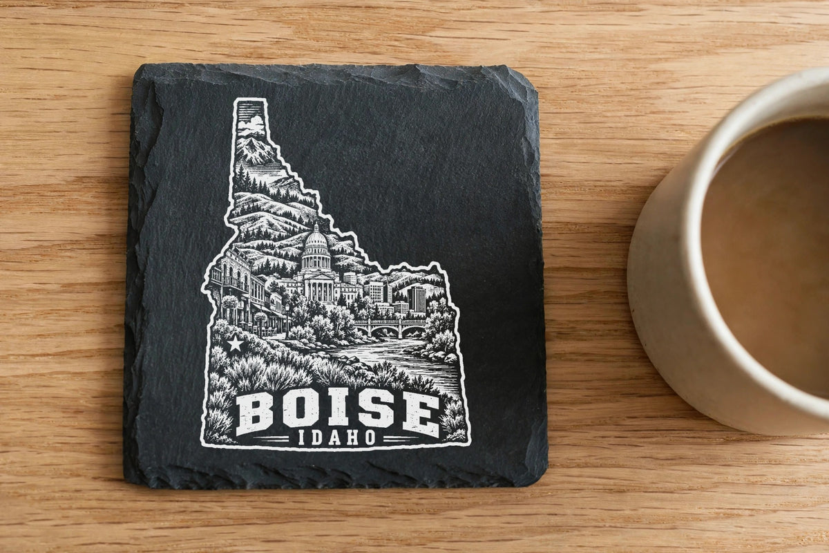 Square black slate coaster featuring a white engraved map of Idaho with Boise text and imagery.