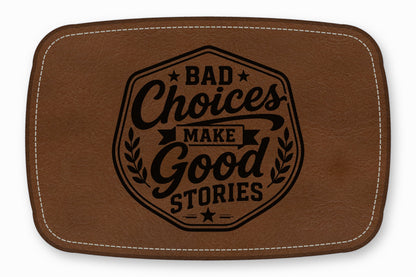 Brown leather patch with white stitching and the engraved text Bad Choices Make Good Stories.