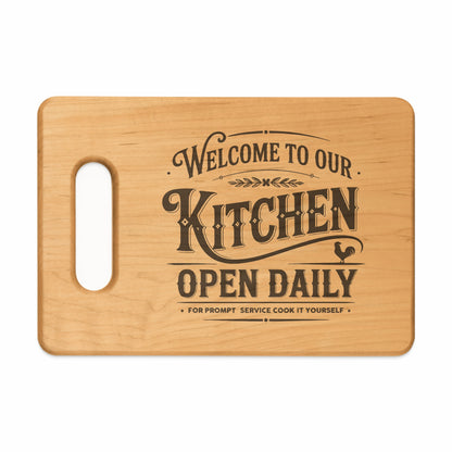 Wooden cutting board with "Welcome to our Kitchen Open Daily" text and rooster graphic.
