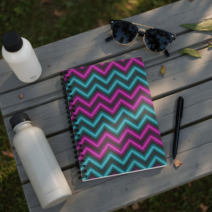 Spiral notebook with neon zig-zag pattern and black pen on wooden surface.