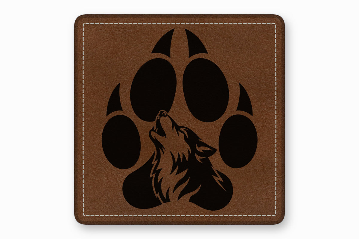 Square brown leather patch with white stitched border and a black howling wolf inside a paw print.