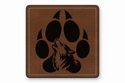 Square brown leather patch with white stitched border and a black howling wolf inside a paw print.