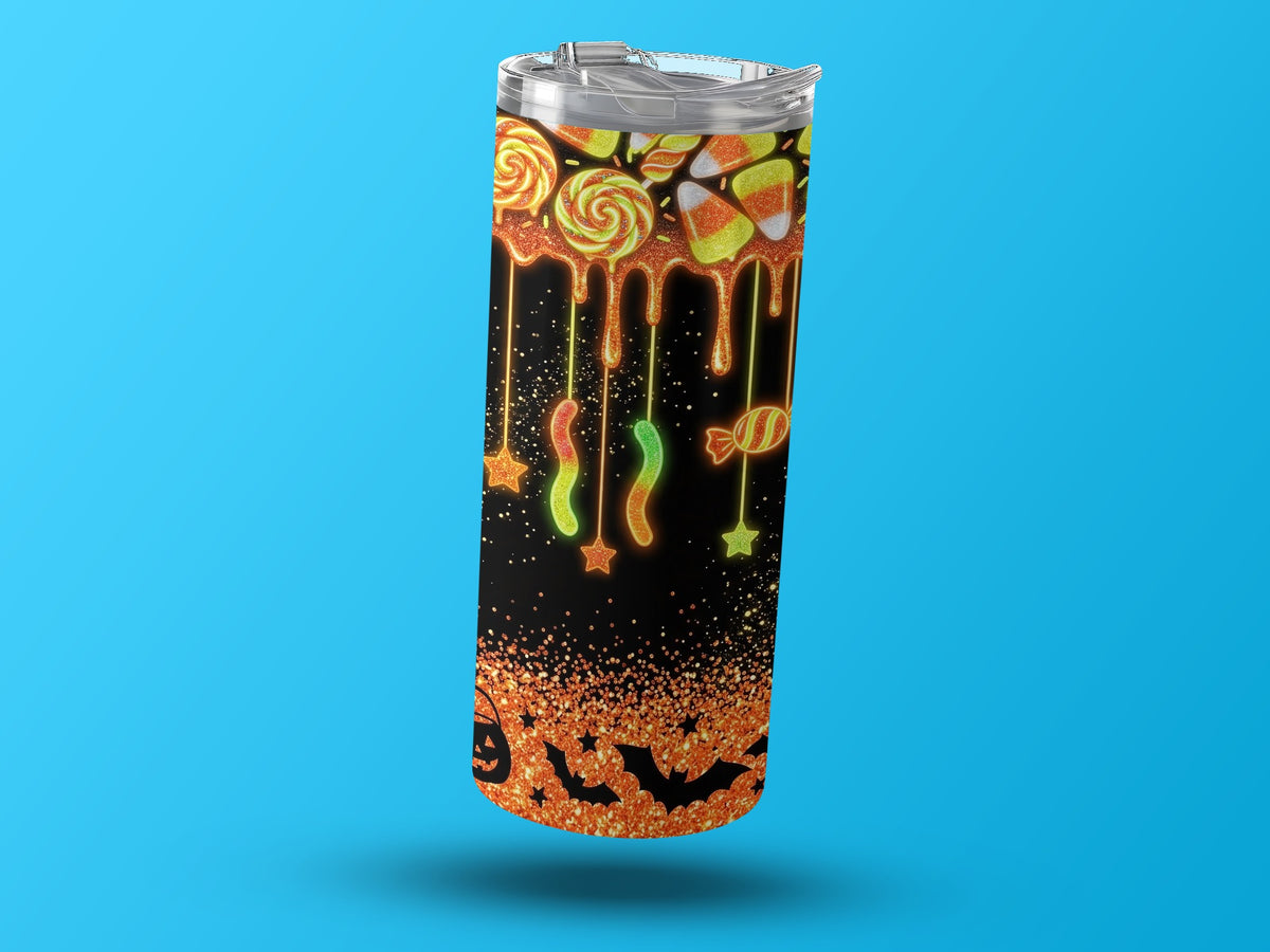 Halloween tumbler with candy, bats, and glitter design on black background.