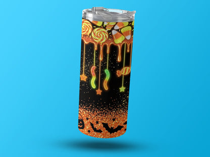 Halloween tumbler with candy, bats, and glitter design on black background.
