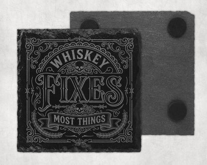 Slate coaster with "Whiskey Fixes Most Things" text and skull graphic.