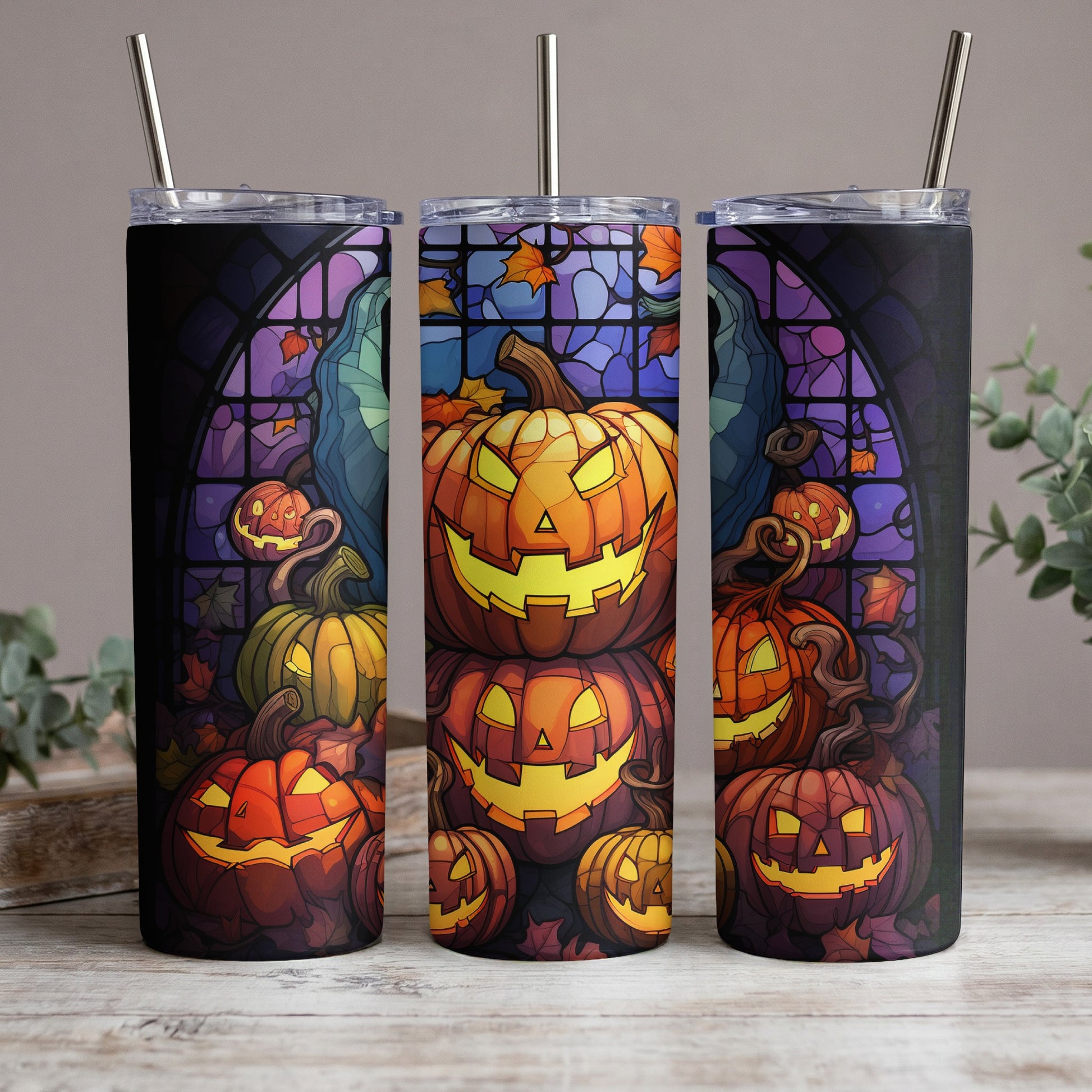 Three tumblers featuring a stained glass-style Halloween pumpkin design with autumn leaves.
