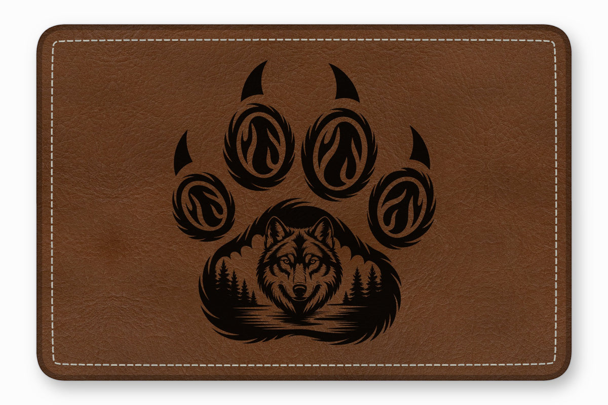 Brown leather patch with white stitched edges featuring an engraved black wolf and paw print design.