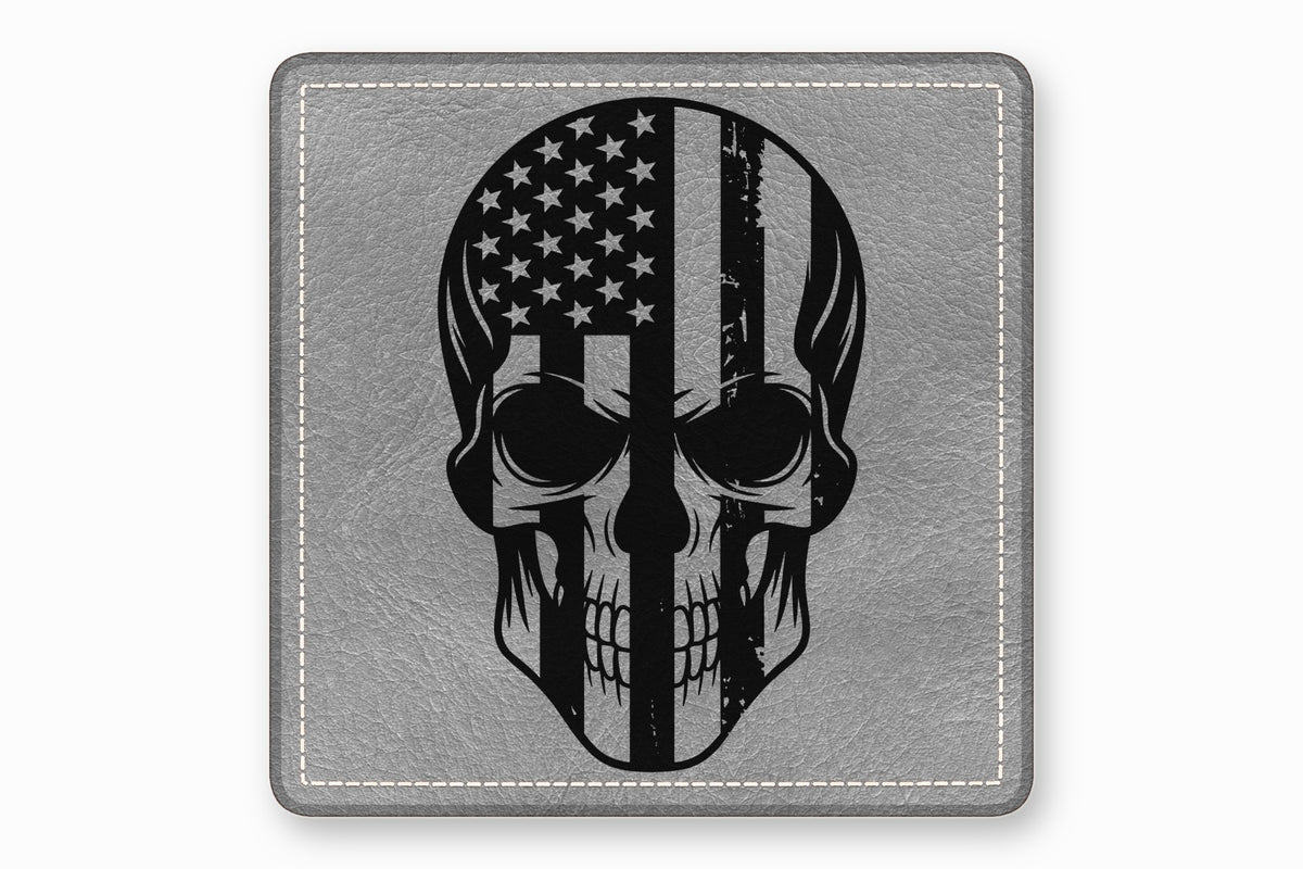 A square gray leather patch featuring a black skull graphic with a distressed American flag pattern.