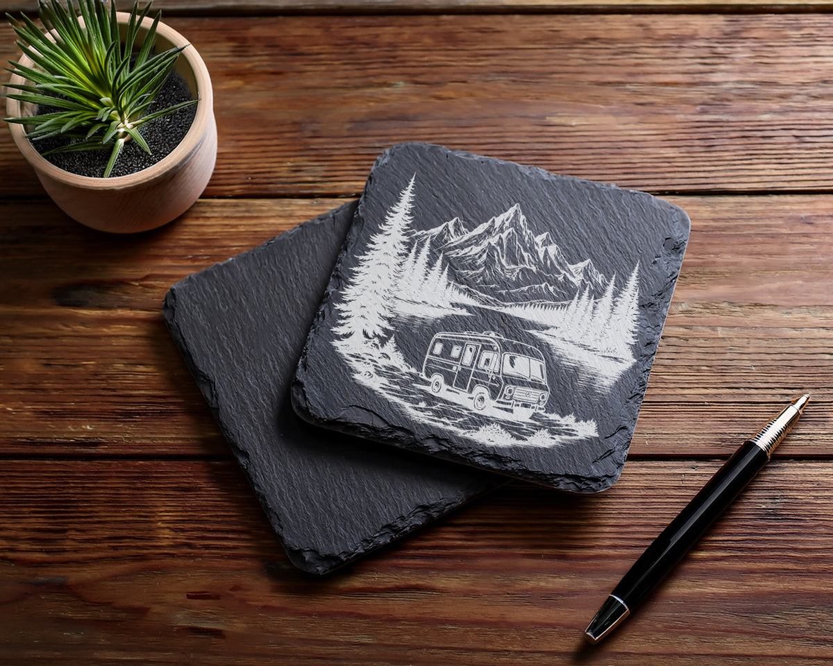 Engraved slate coaster with a vintage camper, trees, and mountains scene.